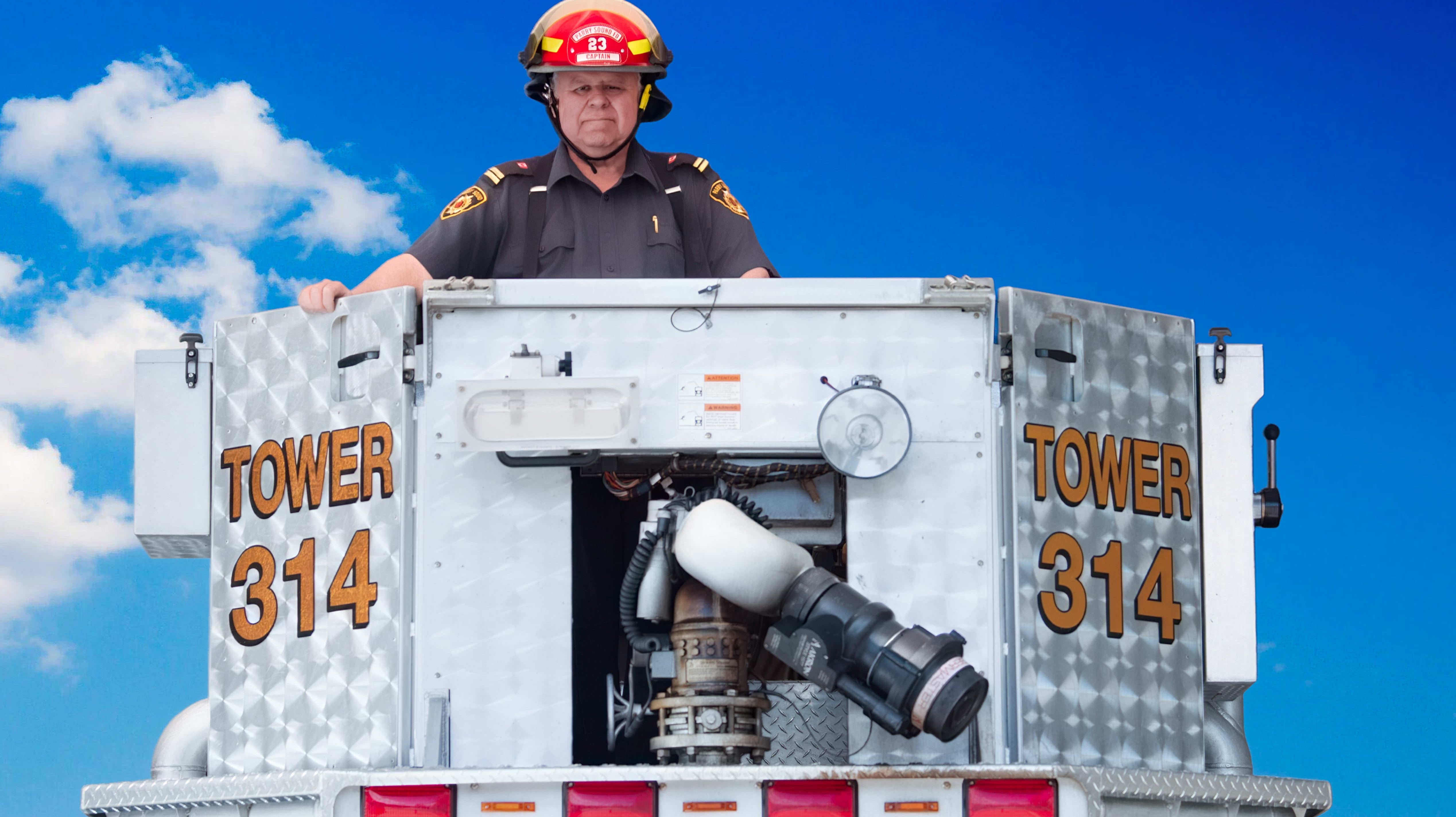 John Tuck in the bucket of a fire truck