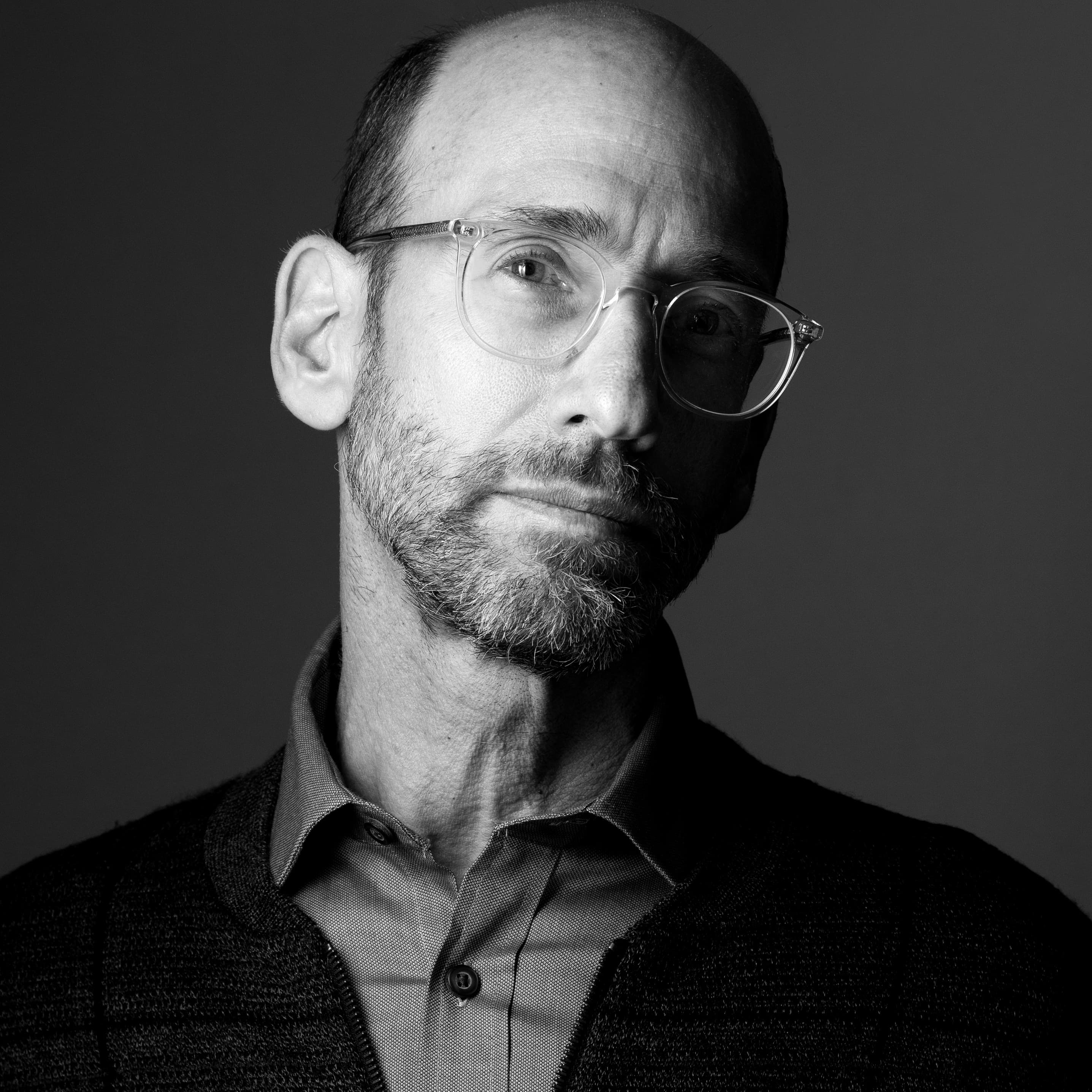 black and white headshot of a man with a beard and glasses