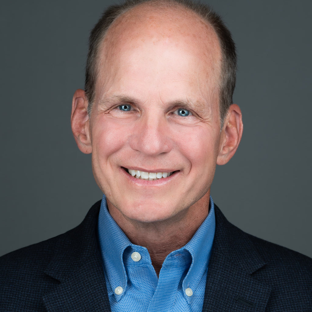 corporate headshot of man in blue shirt and jacket