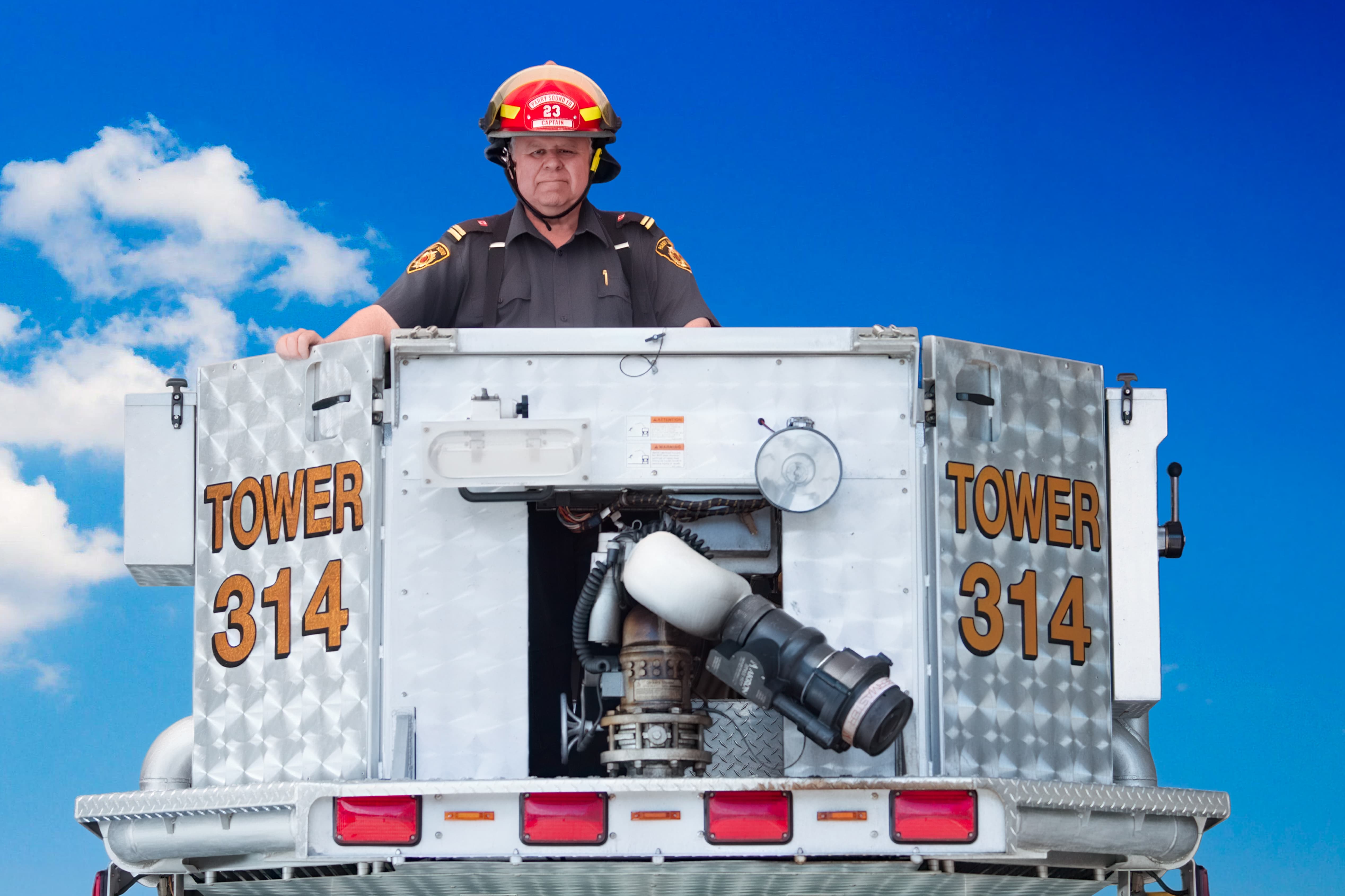 John Tuck in the bucket of a fire truck