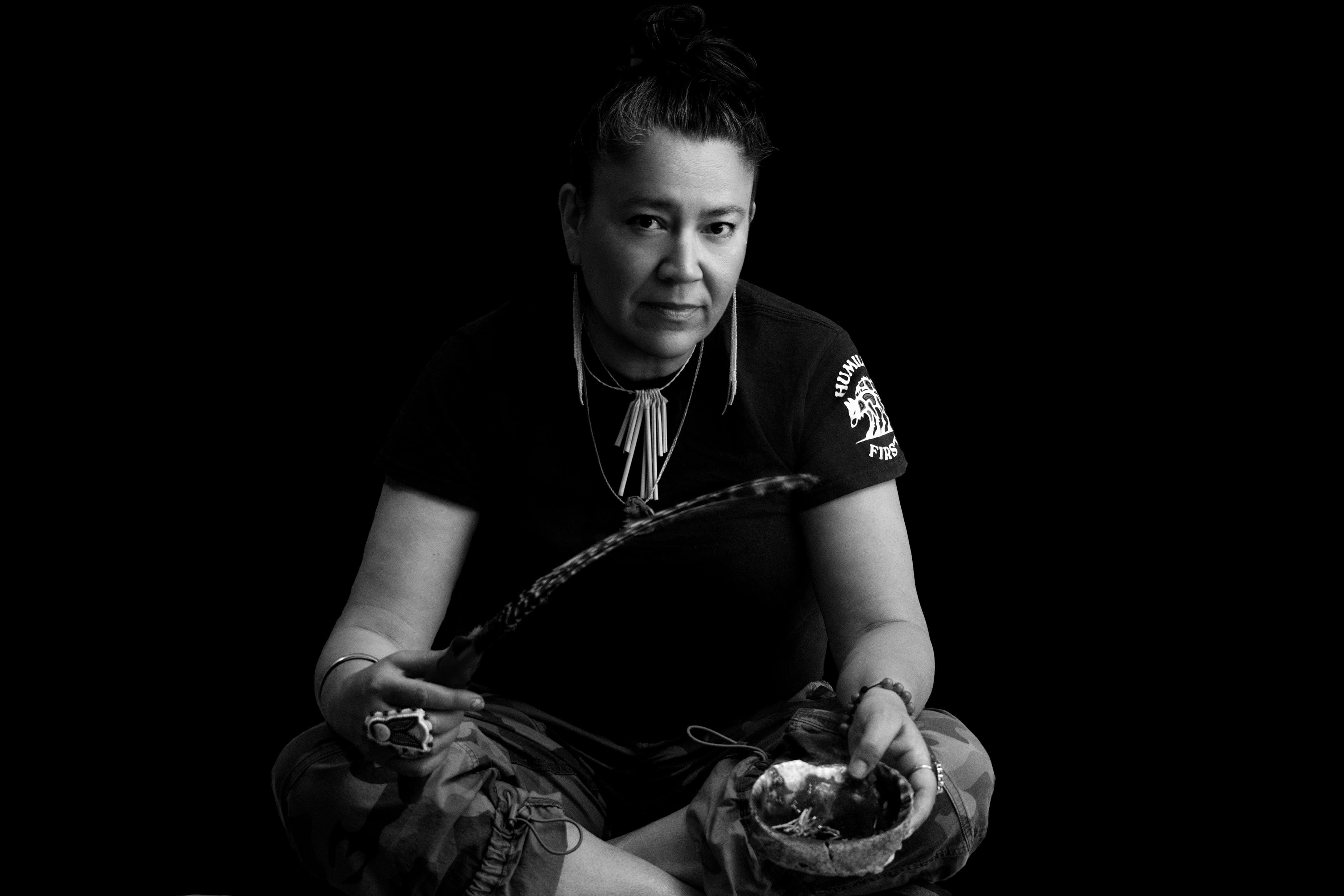 black and white of Johna sitting with a feather