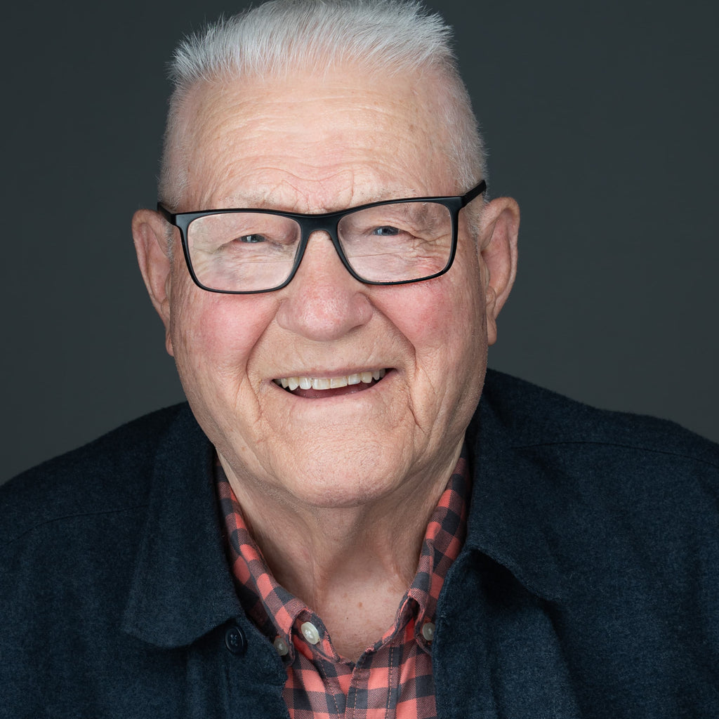 professional headshot of an elderly man wearing glasses