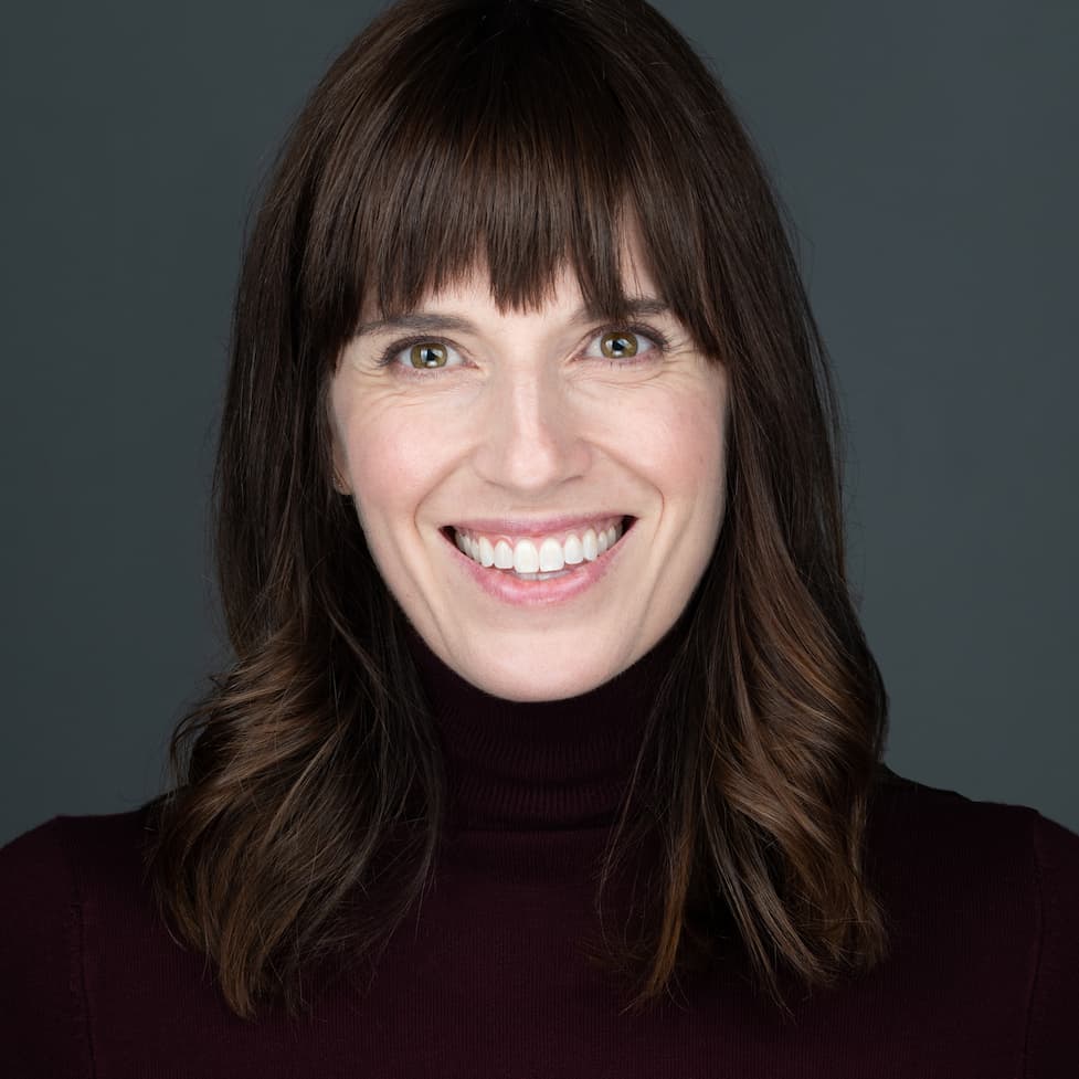 professional headshots of women wearing a dark top on a gray background